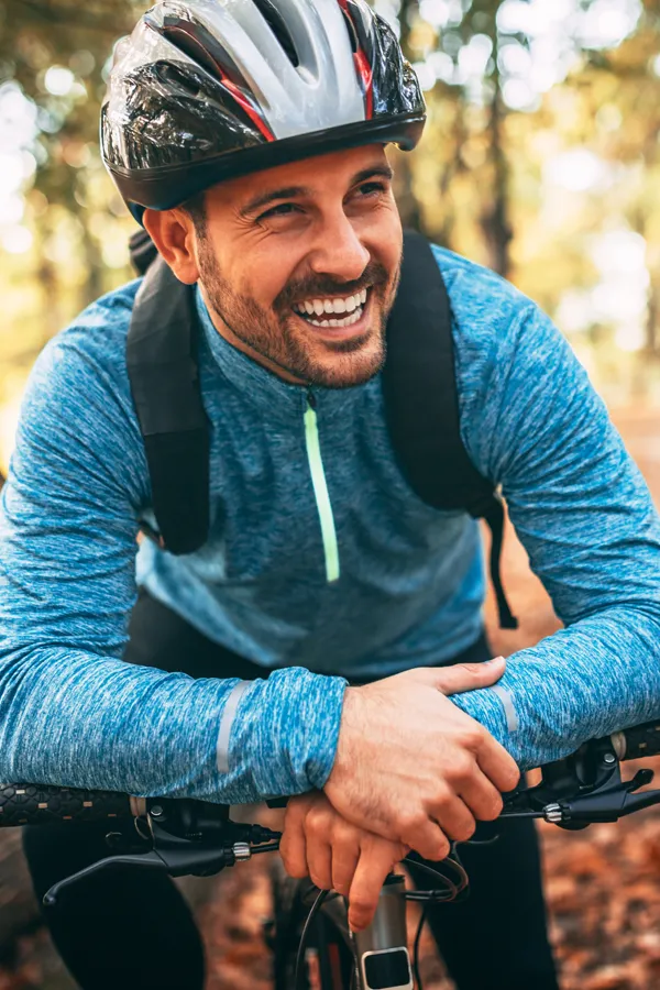 Adrenal-Hormone-Disorder-Treatment A smiling man getting ready for a cycling trip. Get treatment for adrenal hormone disorder from Markham Natural Health Centre in Greater Toronto.