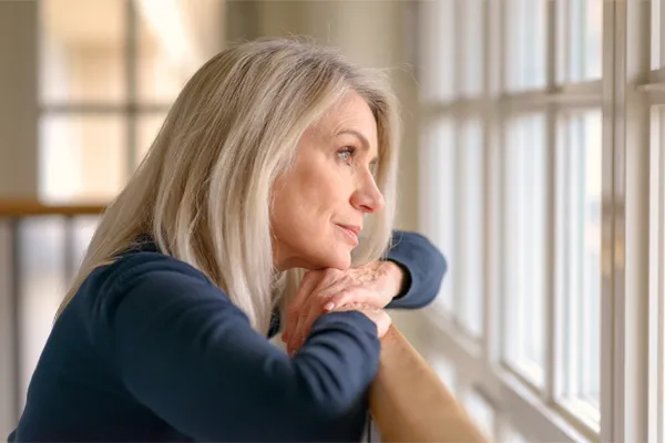 Brain-Fog-Clinic A thoughtful woman gazes out a window, symbolizing the mental fatigue and distraction often associated with brain fog. Get root-cause brain fog treatment by Markham Natural Health Centre in Greater Toronto.