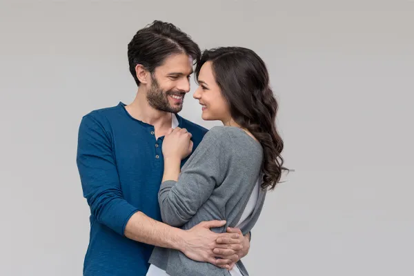 Erectile-Dysfunction-Doctor A man in a blue shirt embracing a woman in a gray shirt smiles due to his successful erectile dysfunction care from Markham Natural Health Centre in Greater Toronto.
