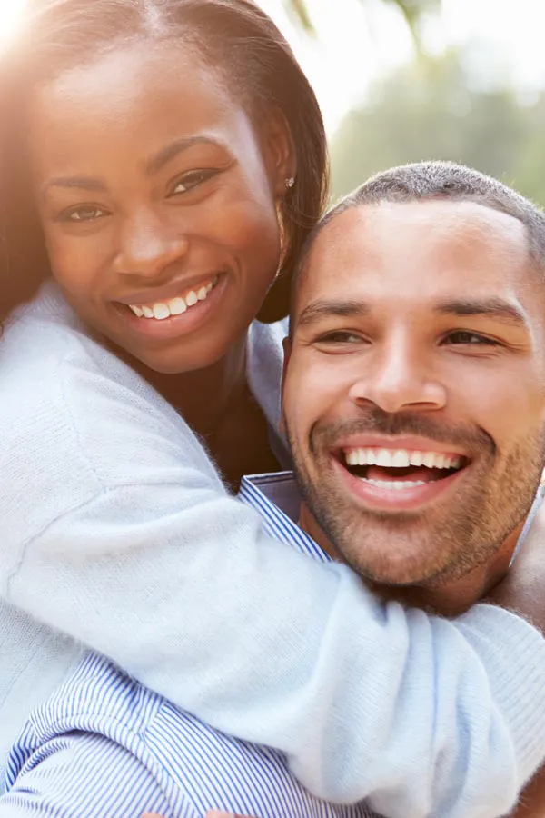 Erectile-Dysfunction-Treatment A woman riding on a man's back, both smiling due to help with erectile dysfunction from Markham Natural Health Centre in Greater Toronto.
