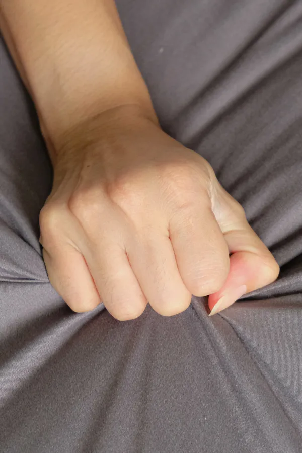 Female-Sexual-Dysfunction-Treatment Close-up of a woman's hand grabbing a sheet, indicating sexual pleasure. Get female sexual dysfunction treatment from Markham Natural Health Centre in Greater Toronto.
