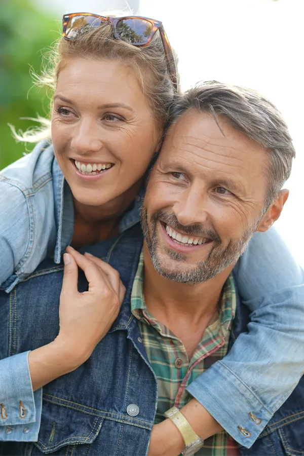 Hypogonadism-Treatment A couple in denim jackets embrace playfully outdoors. Get hypogonadism treatment from Markham Natural Health Centre in Greater Toronto.