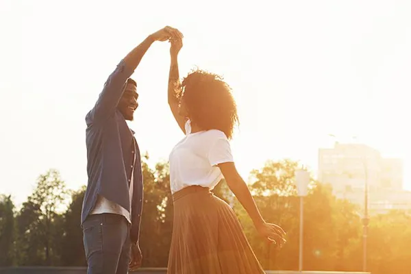 Immunotherapy-Clinic A Black couple dance outside in the sunset. Get treatment for immune support from Markham Natural Health Centre in Greater Toronto.