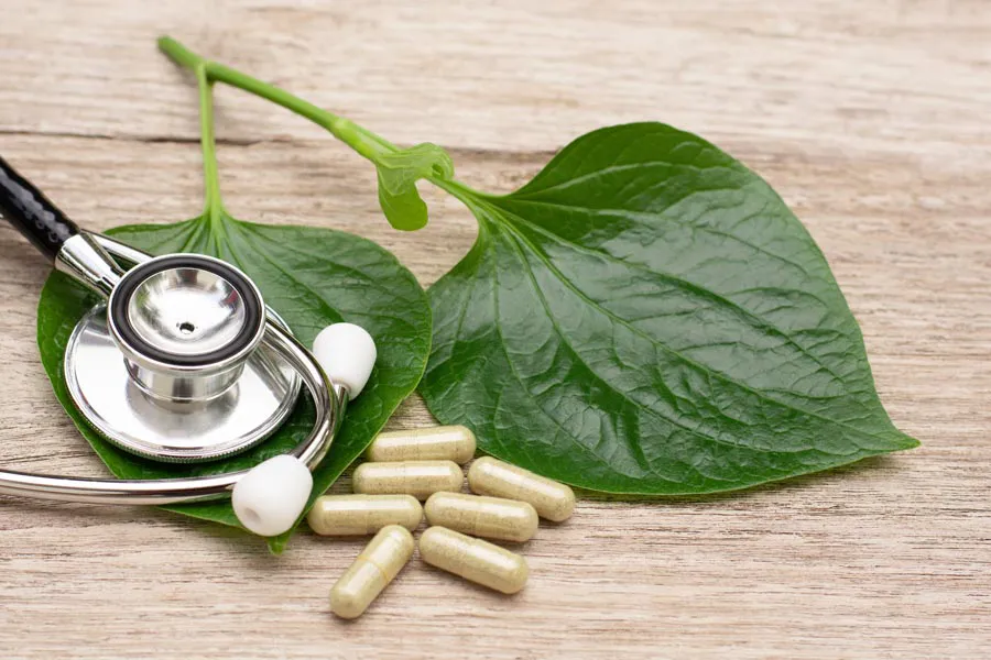 Integrative-Medicine-Clinic A stethoscope, leaves, and medicine capsules on a wood table, representing Integrative Medicine provided by Markham Natural Health Centre in Greater Toronto.