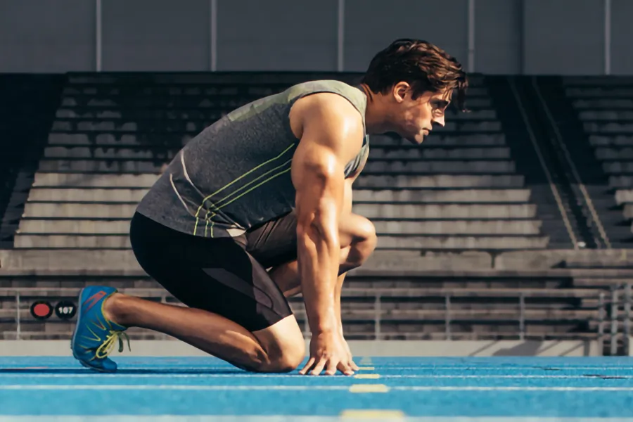 Lean-Muscle-and-Recovery-Clinic A white man kneels at the starting line on a track, determined to do his best. Get treatment for lean muscle loss and recovery from Markham Natural Health Centre in Greater Toronto.