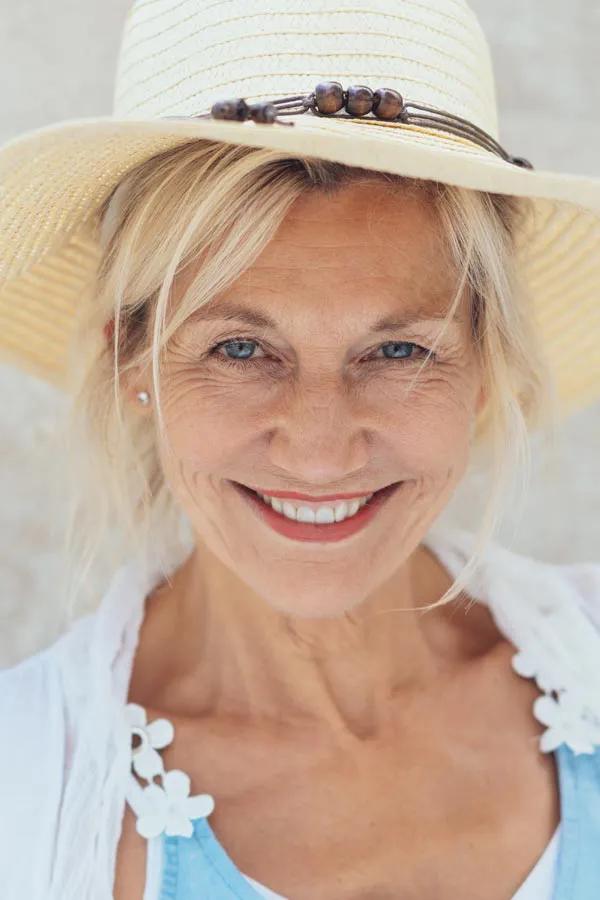 Menopause-Treatment A beautiful, smiling older woman with blonde hair and a sunhat, happy with menopause treatment from Markham Natural Health Centre in Greater Toronto.