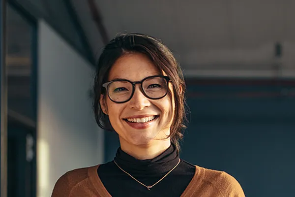 Metabolic-Syndrome-Clinic A brunette woman with glasses smiles in a gray-blue walled office. Get metabolic syndrome from Markham Natural Health Centre in Greater Toronto.