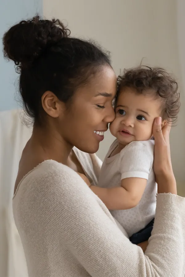 Postpartum-Hormone-Imbalance-Treatment A black woman happily touches her forehead to her infant's head. Get treatment for postpartum hormone imbalance from Markham Natural Health Centre in Greater Toronto.