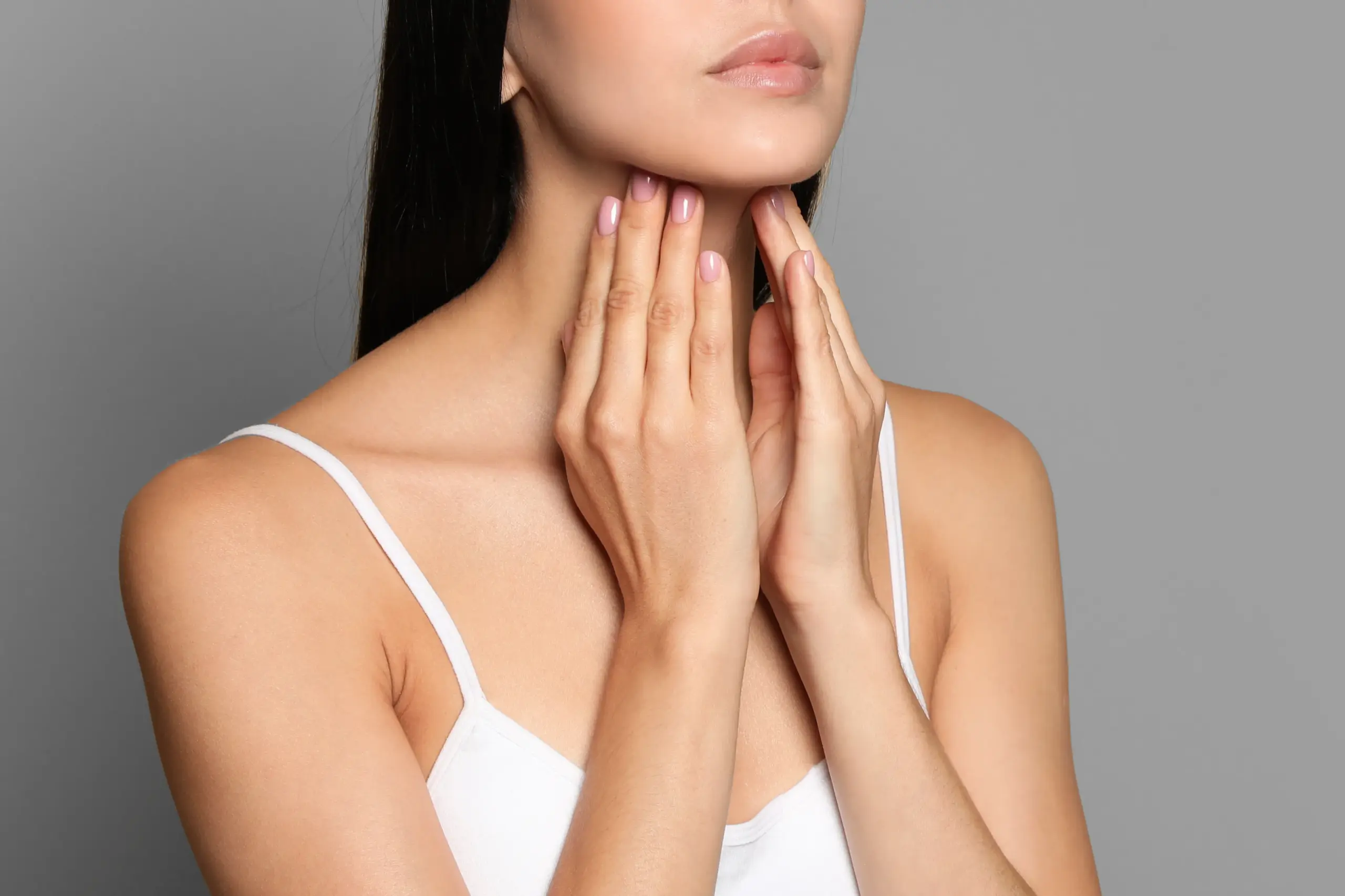 Thyroid-Doctor A woman in a white tank top touches her neck looking for signs of thyroid disorder. Get help for thyroid disorders from Markham Natural Health Centre in Greater Toronto.