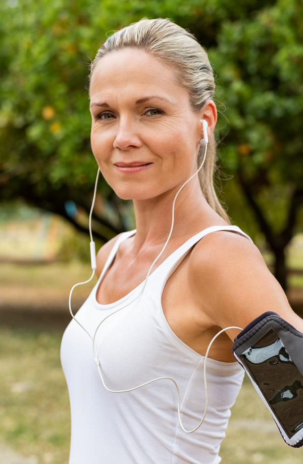fibromyalgia-doctor Middle-aged, active woman taking a break to smile at the camera during a run, representing successful Bioidentical Hormones for Fibromyalgia Relief offered by Markham Natural Health Centre in Greater Toronto.